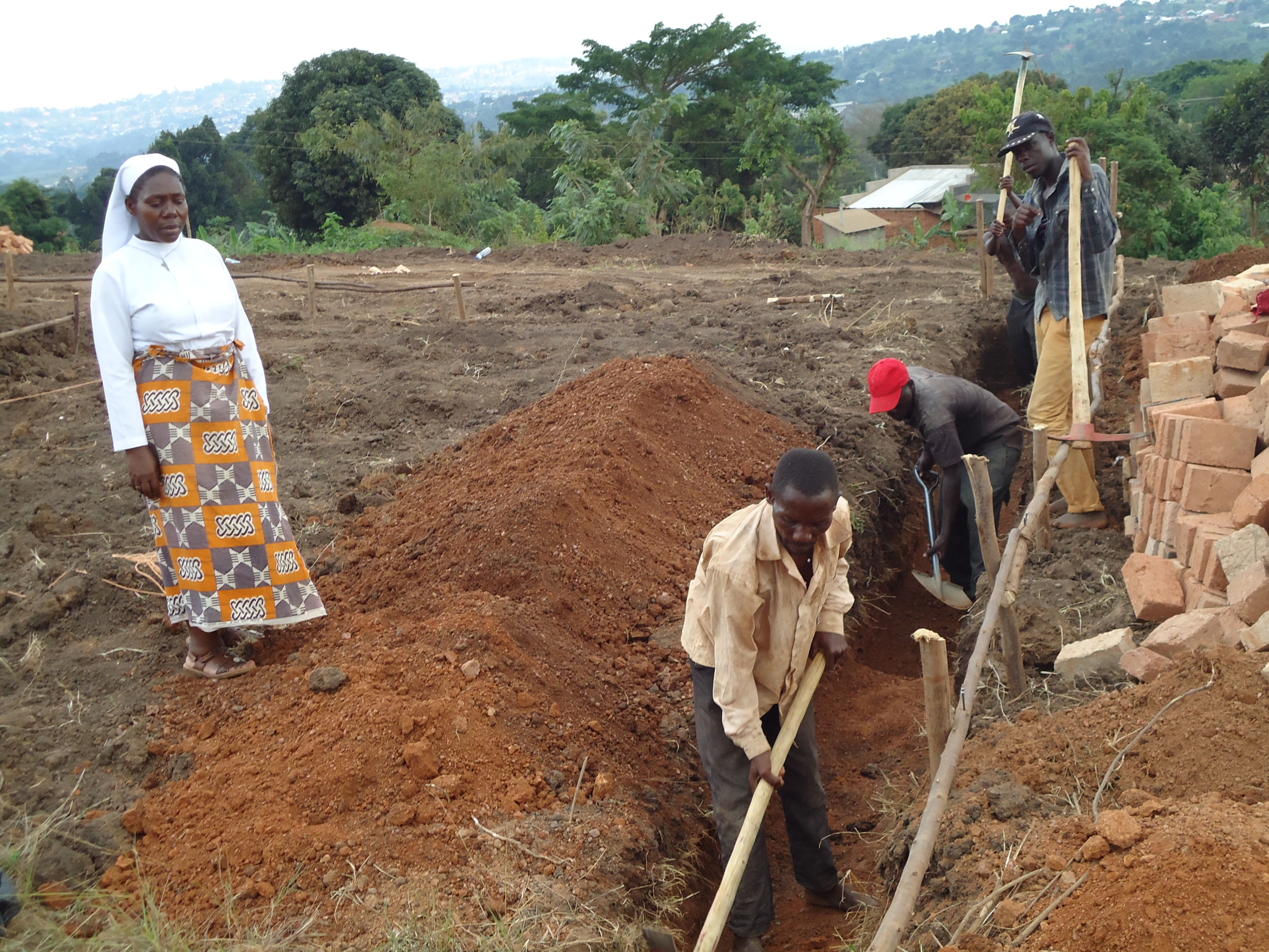 Man making foundation excavation while Sister looks on